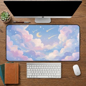 May include: A rectangular desk mat featuring a dreamy sky scene with fluffy pink and white clouds, a crescent moon, and shooting stars against a blue background. The mat is surrounded by a black border.