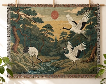 May include: A woven tapestry wall hanging featuring a landscape with three white cranes, pine trees, a flowing stream, and a red sun. The rectangular textile has a fringed border and is suspended from a wooden rod with clips, displaying a detailed nature scene.