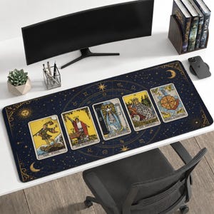 Könnte beinhalten: Rechteckige Schreibtischunterlage mit dunkelblauem Hintergrund, Himmelsdesign und Tarotkarten-Illustrationen. Die Matte zeigt die Karten "Der Narr", "Der Magier", "Die Hohepriesterin", "Die Kaiserin" und "Rad des Schicksals".