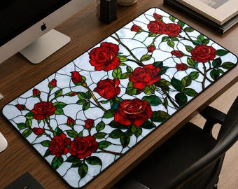 May include: A rectangular desk mat featuring a stained glass pattern of vibrant red roses with green leaves and stems against a light blue and white background. The design consists of interconnected dark lines forming a grid-like floral motif.
