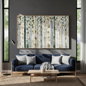 Op de afbeelding: Een groot rechthoekig wandkunstwerk met een aquarel van een dicht bos met verticale boomstammen in tinten groen, bruin en blauw. Het kunstwerk is ingelijst in een dunne, lichtgekleurde houten lijst en is bevestigd aan een donkere muur.