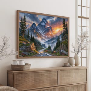 Peut inclure: Une impression d'art murale encadrée de forme rectangulaire représentant un paysage de sommets montagneux enneigés, un chemin sinueux et des forêts de conifères denses sous un ciel de coucher de soleil aux nuages orange, jaunes et bleus.