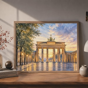 May include: A framed wall art print depicting the Brandenburg Gate in Berlin at sunset, featuring the neoclassical monument with its columns and quadriga statue illuminated by golden light, set against a sky with soft clouds and trees.