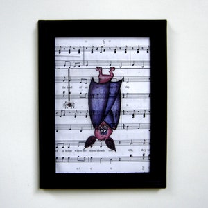 May include: A framed illustration of a purple bat hanging upside down from sheet music. The bat has a pink face and is smiling. The sheet music has the words "the land of an unclouded sky" and "a home where no storm clouds rise".