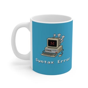 May include: White ceramic mug with a blue background featuring a pixelated computer with a sad face and steam rising from it. The text "Syntax Error" is printed below the computer in white.