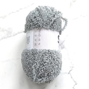 May include: A set of three ceramic mugs with a speckled, matte finish. The mugs are in shades of cream, light gray, and dark gray. Each mug has a simple, minimalist design, perfect for coffee or tea.