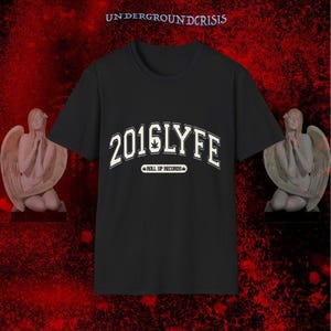 Puede incluir: Camiseta negra con el texto "2016LYFE" en blanco, con letras arqueadas y un gráfico de hoja de cannabis. El texto "ROLL UP RECORDS" está debajo. El fondo es un degradado rojo oscuro con estatuas de ángeles a ambos lados.