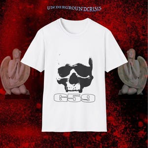 May include: White t-shirt with a large black skull design and the text "G59" in a sans-serif font. The words "UNDERGROUNDCRISIS" are printed above the shirt. The shirt is set against a red background with angel statues on either side.