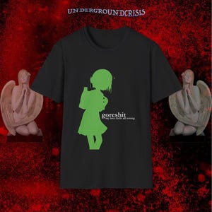 Könnte beinhalten: Schwarzes T-Shirt mit einer grünen Silhouette einer Person und dem Text "goreshit my love feels all wrong". Das T-Shirt hat einen Rundhalsausschnitt. Die Worte "UNDERGROUNDCRISIS" stehen oben. Zwei Engelsstatuen befinden sich auf beiden Seiten.