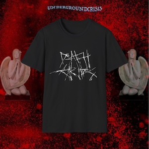 May include: Black t-shirt featuring the white text "DEATH SKIES" in a distressed, handwritten style. The shirt is displayed with two angel statues on a red background, and the text "UNDERGROUNDCRISIS" is at the top.