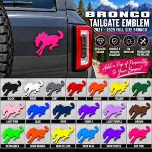 May include: A Bronco tailgate emblem for 2021-2025 full size vehicles, featuring a 3D raised horse design. The image displays a color chart with twenty-four options including black, white, gray, red, orange, yellow, green, pink, blue, navy, purple, brown, and neon variations.