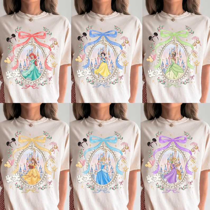 Pu&ograve; includere: T-shirt color crema con vari disegni di principesse Disney. Ogni maglietta presenta una principessa all'interno di una cornice ovale, adornata da fiocchi, orecchie di Topolino e accenti floreali. Le principesse includono Ariel, Biancaneve, Tiana, Belle, Cenerentola e Rapunzel.