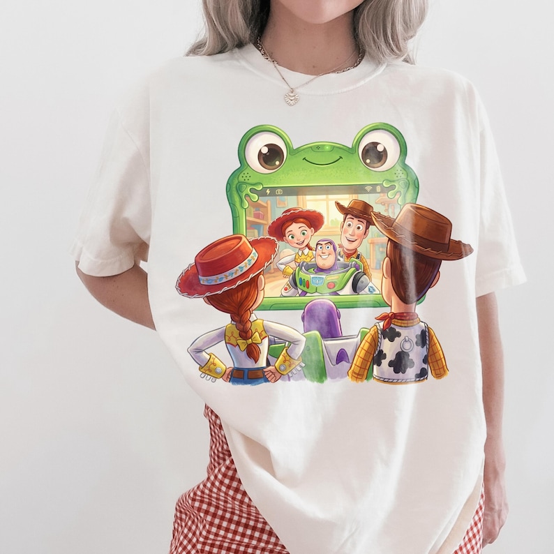 Puede incluir: Camiseta de color crema con una colorida ilustraci&oacute;n de personajes de la pel&iacute;cula de animaci&oacute;n Toy Story. El dise&ntilde;o incluye a Woody, Jessie, Buzz Lightyear y otros personajes. La camiseta tiene cuello redondo y mangas cortas.