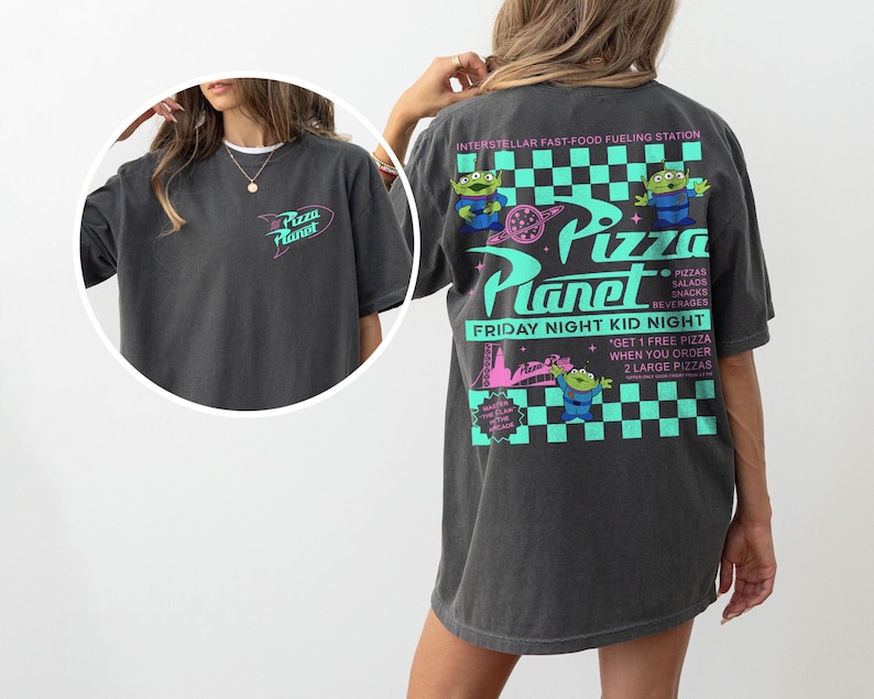 May include: Dark gray t-shirt with a Pizza Planet logo on the front and back. The back features the text "INTERSTELLAR FAST-FOOD FUELING STATION" and "FRIDAY NIGHT KID NIGHT" with alien characters and pizza graphics.