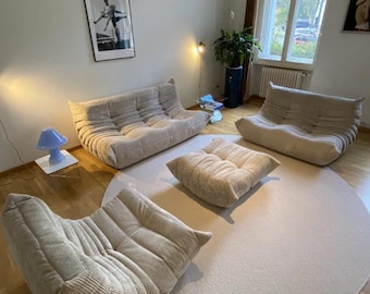 Conjunto de sofás Ligne Roset Togo de pana beige: sofá de 3 plazas, sofá de 2 plazas, sofá de 1 plaza y otomana.