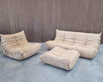 Conjunto de sofás Ligne Roset Togo en Alcantara beige/crema: sofá de 3 plazas, sillón de 1 plaza y otomana.