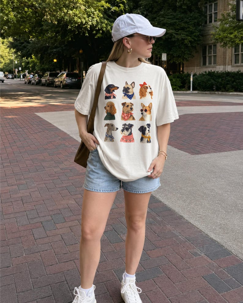 Puede incluir: Una camiseta de manga corta color hueso con una cuadr&iacute;cula de nueve retratos de perros ilustrados, cada uno con un accesorio diferente como un pa&ntilde;uelo, un su&eacute;ter o un lazo. La prenda se combina con pantalones cortos de mezclilla azul claro.