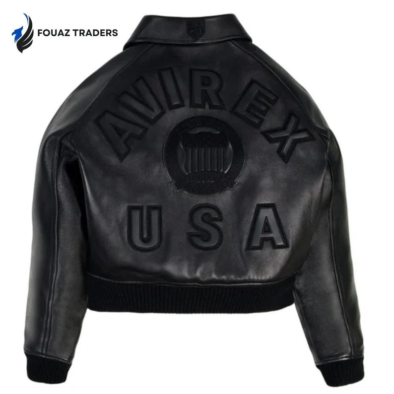 May include: Black leather jacket with the text "AVIREX USA" on the back. The jacket has a ribbed hem and cuffs, a collar, and a logo on the upper back. The jacket is a bomber style.