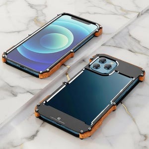May include: Two smartphone cases with a unique design. The cases feature a black frame with silver accents, wooden-look trim, and a clear back. The phone screens display a blue and white gradient. The cases are designed to protect the phone.