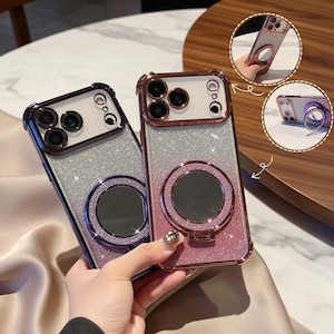 May include: Two glittery phone cases with a gradient effect, transitioning from silver to purple and silver to pink. Each case has a metallic ring holder and a camera lens protector. The cases are designed to protect the phone.