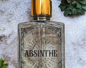 May include: A clear glass dropper bottle with a gold collar and black dropper top. The label features the text Puradiance, Absinthe, and 30 ml, surrounded by a decorative black border and sunburst graphic. The bottle contains a clear liquid.