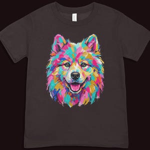 A dark brown short-sleeved t-shirt printed with a vibrant pop art illustration of a smiling fluffy puppy.