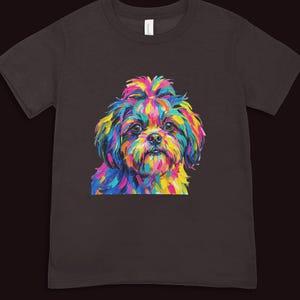 A dark brown short-sleeved t-shirt featuring a vibrant pop art illustration of a fluffy dog's face.