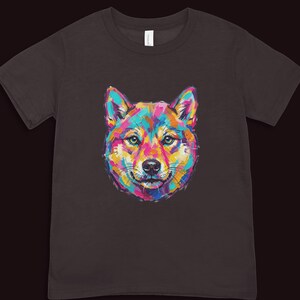 A dark brown short-sleeved t-shirt displaying a colorful pop art portrait of a Shiba Inu style dog.