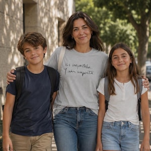 May include: A light grey crew neck t-shirt featuring the black printed text 'Si importaba. Y aún importa.' The shirt is worn with blue denim jeans, a dark blue t-shirt, khaki cargo shorts, a white t-shirt, and light blue denim shorts.