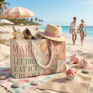 Può includere: Una borsa tote in tela beige con manici in corda che riporta il testo MARIE ANTOINETTE LET THEM EAT ICE CREAM, un ritratto e un grafico a forma di gelato. È accessoriata con un cappello di paglia con fascia rosa, occhiali e crema solare.