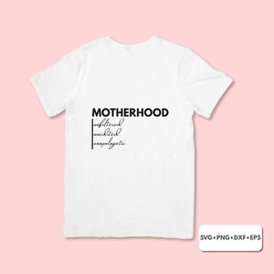 Könnte beinhalten: Weißes T-Shirt mit dem Wort "MOTHERHOOD" in fetter, schwarzer Schrift, gefolgt von den Wörtern "unfiltered, unedited, unapologetic" in einer stilvollen, handschriftlichen Schriftart. Das Shirt wird vor einem hellrosa Hintergrund gezeigt.