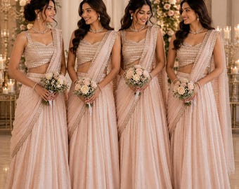 Op de afbeelding: Vier identieke lichtroze lehenga's met mouwloze choli-tops voorzien van ingewikkeld kralenwerk en bijpassende geplooide rokken. Elk kledingstuk bevat een gedrapeerde dupatta met een decoratieve rand. De personen houden kleine boeketten van witte en roze rozen.