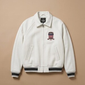 May include: A white zip-up jacket featuring a fold-down collar, long sleeves, and two front pockets. The chest displays an embroidered patch with the text AVIREX above a shield graphic featuring red and white stripes and blue stars.