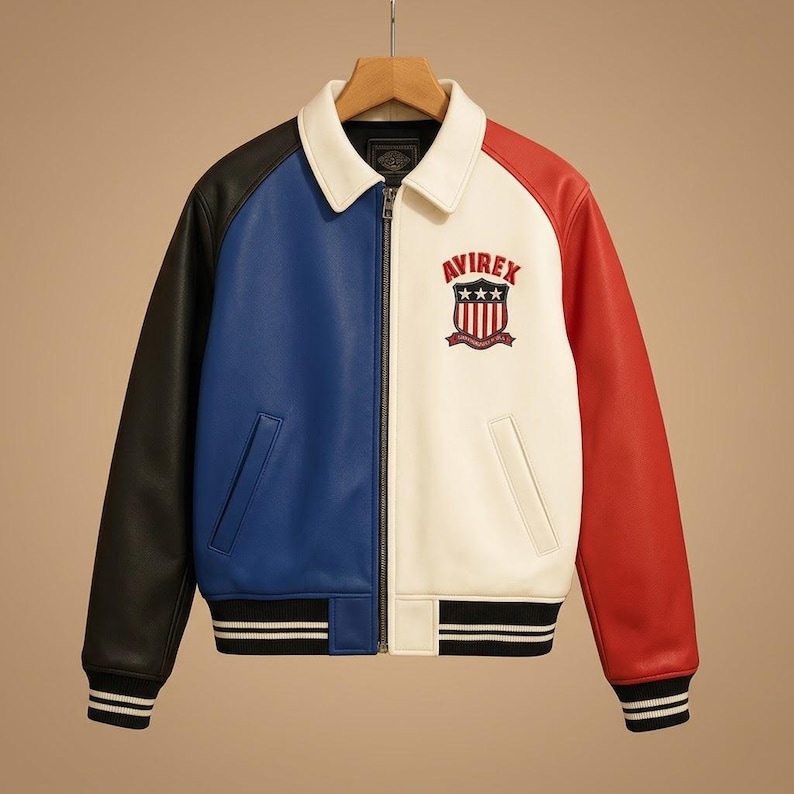 Peut inclure: Une veste color-block avec un col blanc, une manche droite noire, un panneau avant bleu, un panneau avant gauche blanc et une manche gauche rouge. La poitrine pr&eacute;sente un logo &eacute;cusson Avirex brod&eacute; avec des &eacute;toiles et des rayures. Elle poss&egrave;de une fermeture &eacute;clair frontale et des poignets et un ourlet c&ocirc;tel&eacute;s noirs avec des rayures blanches.