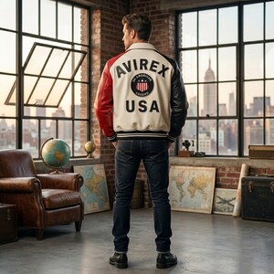 Peut inclure: Une veste de style universitaire avec un panneau arri&egrave;re cr&egrave;me portant le texte AVIREX USA et un logo circulaire, une manche droite rouge et une manche gauche noire. La veste poss&egrave;de un col, des poignets c&ocirc;tel&eacute;s et un ourlet ray&eacute; noir et blanc.