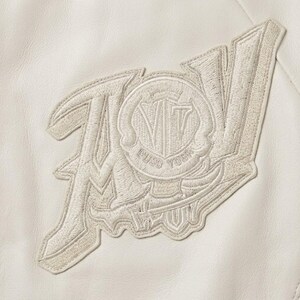 May include: Cream-colored embroidered patch with the letters "AV" and a circular emblem featuring "VT" and the words "PUSO YORK". The patch is sewn onto a cream-colored leather-like material.