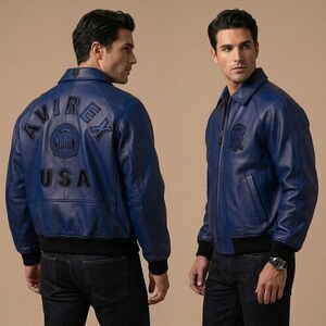 May include: A blue leather jacket with a black collar and cuffs. The back of the jacket features the text "AVIREX USA" in black. The jacket has a zipper closure and a small patch on the chest.