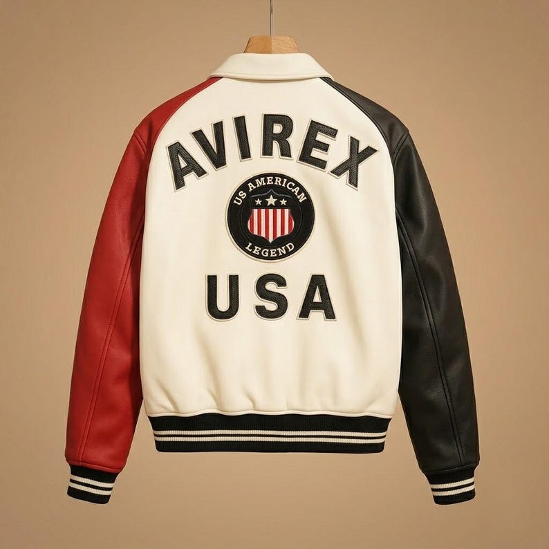 Peut inclure: Une veste style varsity avec un corps cr&egrave;me, une manche gauche rouge et une manche droite noire. Le dos pr&eacute;sente le texte AVIREX et USA en lettres noires, ainsi qu'un &eacute;cusson circulaire portant l'inscription US AMERICAN LEGEND et un bouclier.