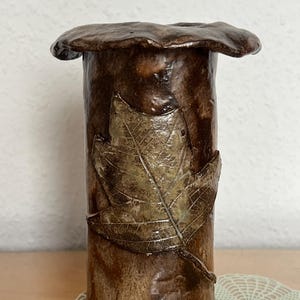 Könnte beinhalten: Rustikales Holzschild mit dem Text "Welcome to our home" in weißer Schrift. Das Schild hat eine Used-Optik und ein schlichtes, einladendes Design, ideal für den Eingangsbereich.