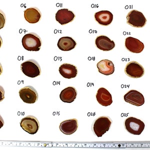 May include: Thirty agate slices with gold trim, numbered 01 to 30. Each slice is a different shade of red, brown, and white.