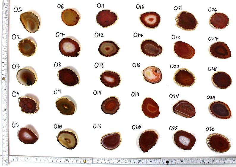 May include: Thirty agate slices with gold trim, numbered 01 to 30. Each slice is a different shade of red, brown, and white.