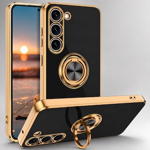 May include: Black and gold phone case with a ring holder. The case has a black back with gold trim and a gold ring holder in the center. The case also has a gold camera surround. The phone screen displays a sunset over the ocean.