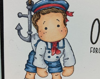 May include: A cartoon illustration of a boy dressed as a sailor holding onto a rope attached to an anchor. He is wearing a blue and red sailor hat, a white shirt with blue buttons, blue shorts, and brown shoes. The background is white with a blue border.