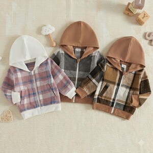 May include: Three long-sleeve zip-up hoodies with hoods and front pockets. The left hoodie is pink and white plaid with a white hood. The middle hoodie is gray and black plaid with a brown hood. The right hoodie is brown and tan plaid with a brown hood.