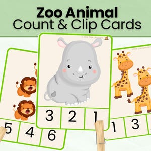 May include: Three rectangular count and clip cards featuring cartoon zoo animals. One card shows two lions, another a single rhinoceros, and the third two giraffes. Each card has a green border and a bottom section with three numbers for clipping.