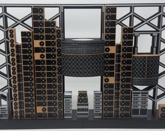May include: A scale model of a server room featuring a black and gray lattice frame backdrop. The structure includes multiple vertical towers of black server racks with circular fan details, a large central cylindrical unit, and smaller rack components.