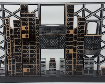 May include: A scale model of a server room featuring a black and gray lattice frame backdrop. The structure includes multiple vertical towers of black server racks with circular fan details, a large central cylindrical unit, and smaller rack components.
