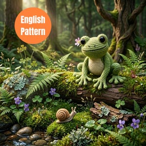 Puede incluir: Una rana verde de ganchillo con grandes ojos negros y una pequeña flor rosa está sentada en un tronco cubierto de musgo. Un caracol se arrastra cerca. La imagen incluye el texto "English Pattern" en un círculo naranja, sobre un fondo de bosque.