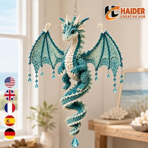 Peut inclure: Une décoration de dragon en crochet suspendue aux couleurs bleu sarcelle et crème. Le dragon possède de grandes ailes avec des perles de cristal bleues pendantes, une longue queue enroulée et des détails de points complexes.