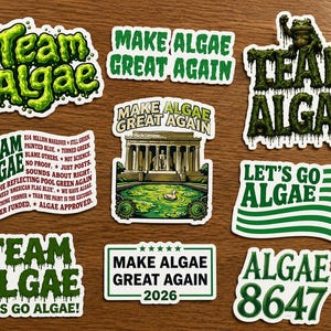 May include: A collection of nine stickers featuring green text and graphics. Designs include the phrases Team Algae, Make Algae Great Again, Let's Go Algae, and Algae 8647. One sticker depicts a building with a reflecting pool, while others use wavy flag motifs.